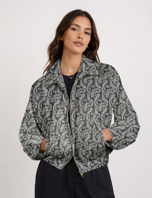 Women's cropped bomber jacket with twin metallic front zippers, welt pockets, elasticated hem and cuffs, and contrast sari print lining.