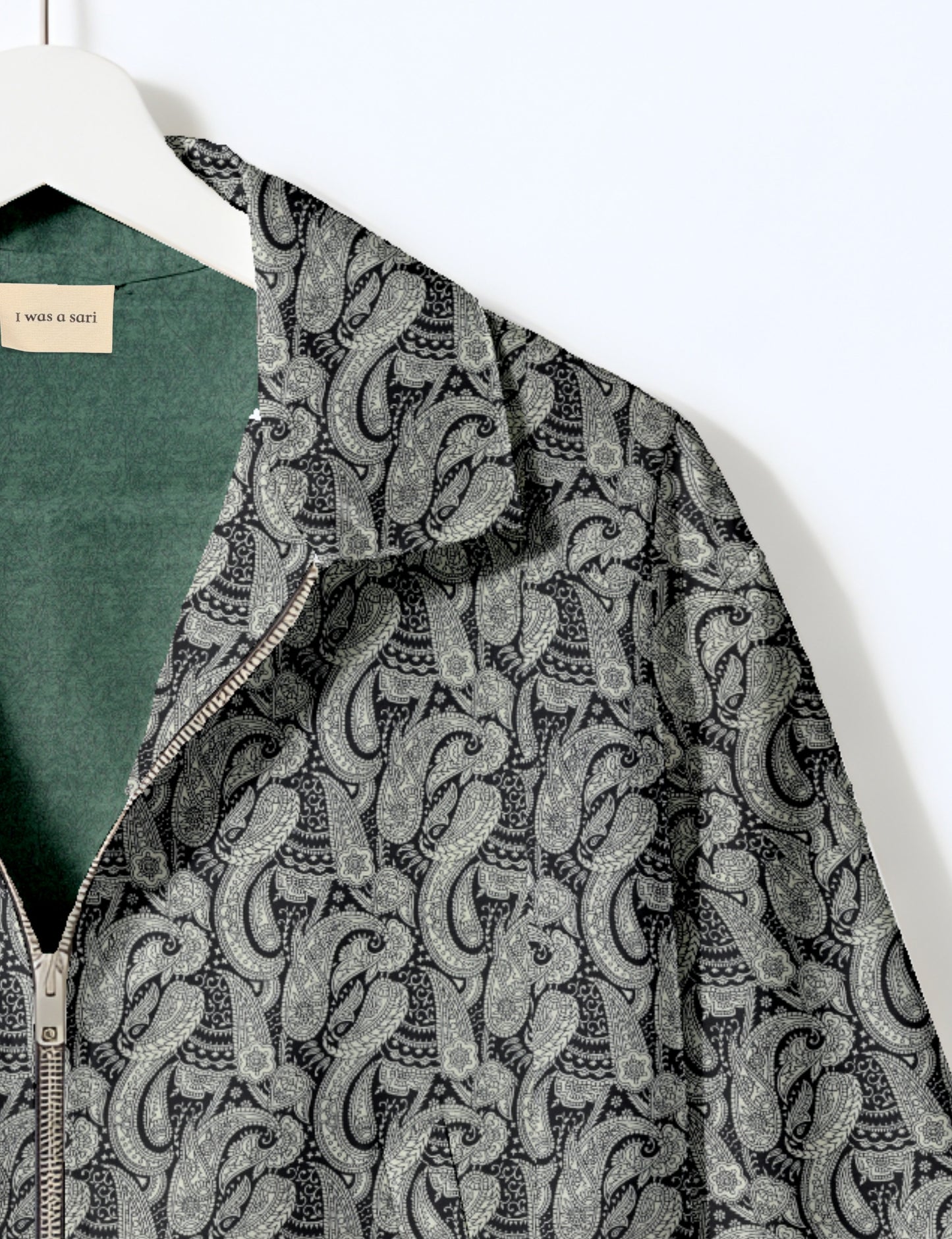 Women's cropped bomber jacket with twin metallic front zippers, welt pockets, elasticated hem and cuffs, and contrast sari print lining.