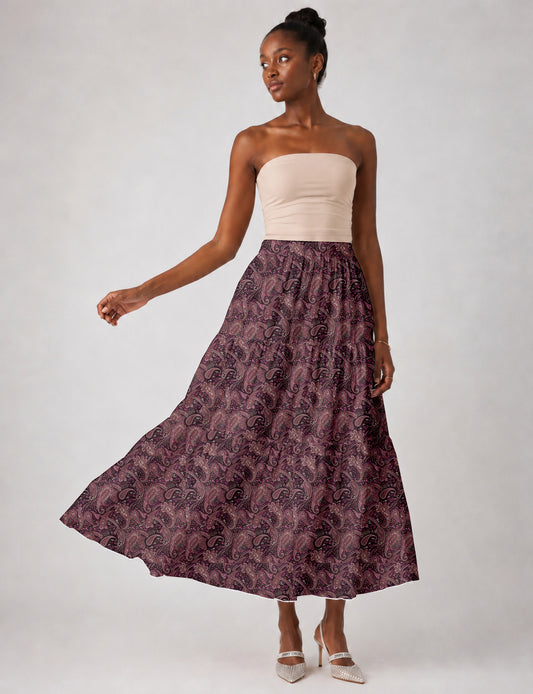 Woman wearing a yellow midi tiered skirt with a small geometric pattern, paired with a beige strapless top and white heels