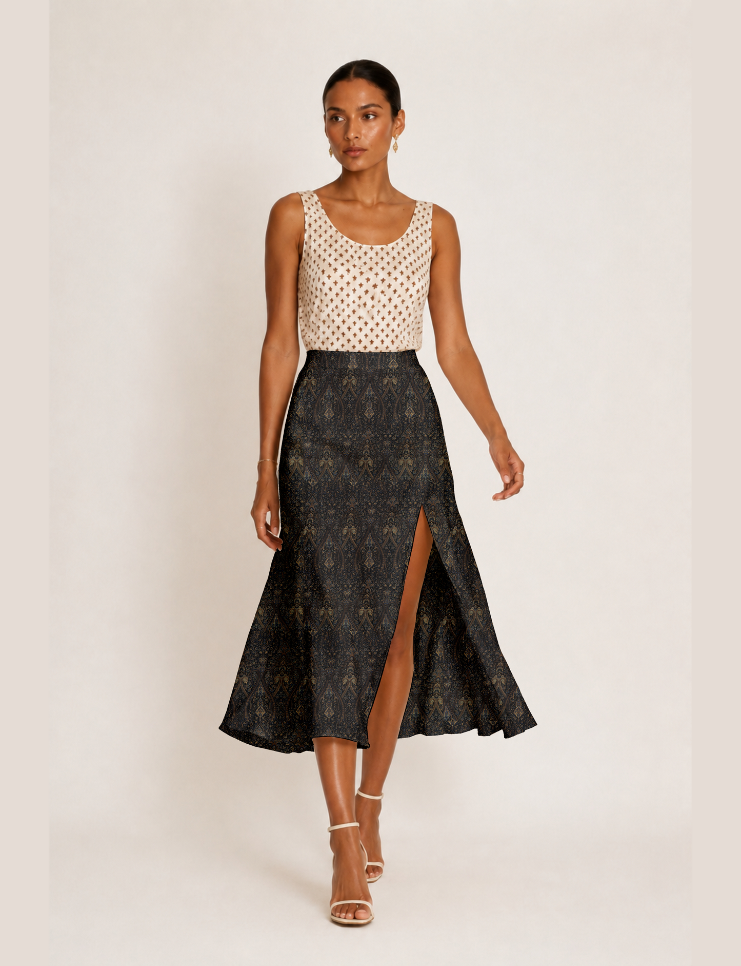 Woman wearing a yellow and black micro patterned A-line skirt with front slit, paired with beige sleeveless top and black