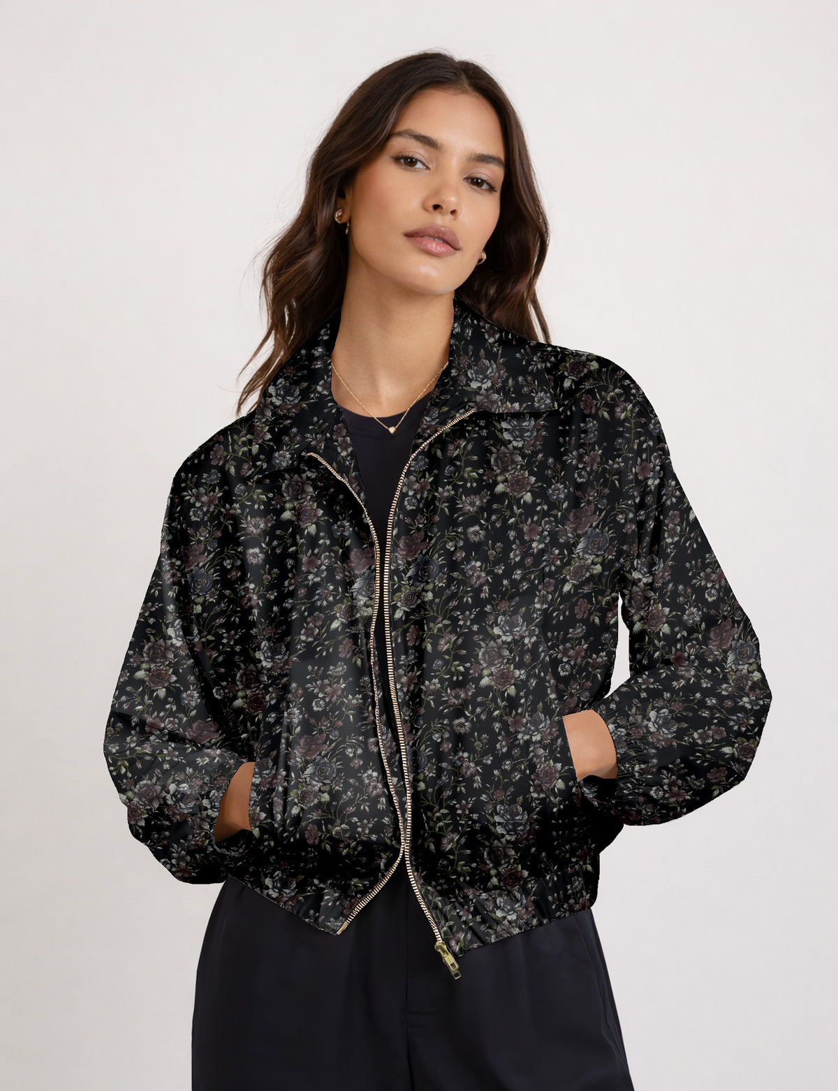Brown floral bomber jacket with front zipper, elastic cuffs and hem, hanging on white hanger, red floral inner lining visible