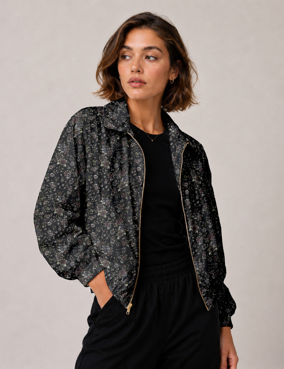 Brown floral bomber jacket with front zipper, elastic cuffs and hem, hanging on white hanger, red floral inner lining visible