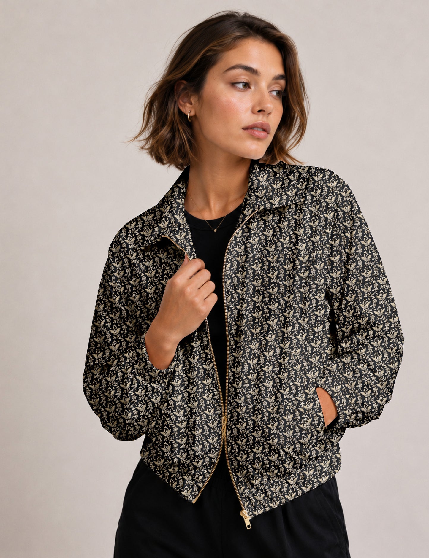 Woman wearing a yellow floral bomber jacket with front zipper, elastic cuffs, and side pockets, shown from front view