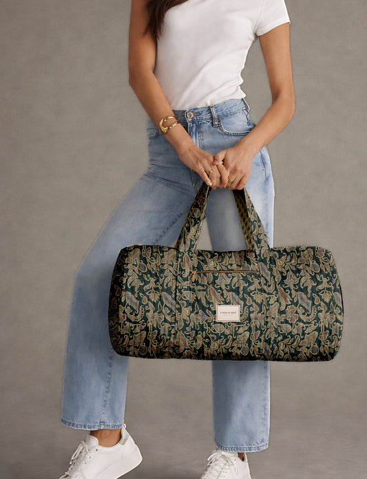 Brown paisley quilted bowling bag with dual handles, front zipper pocket, and "I was a sari" label on front side