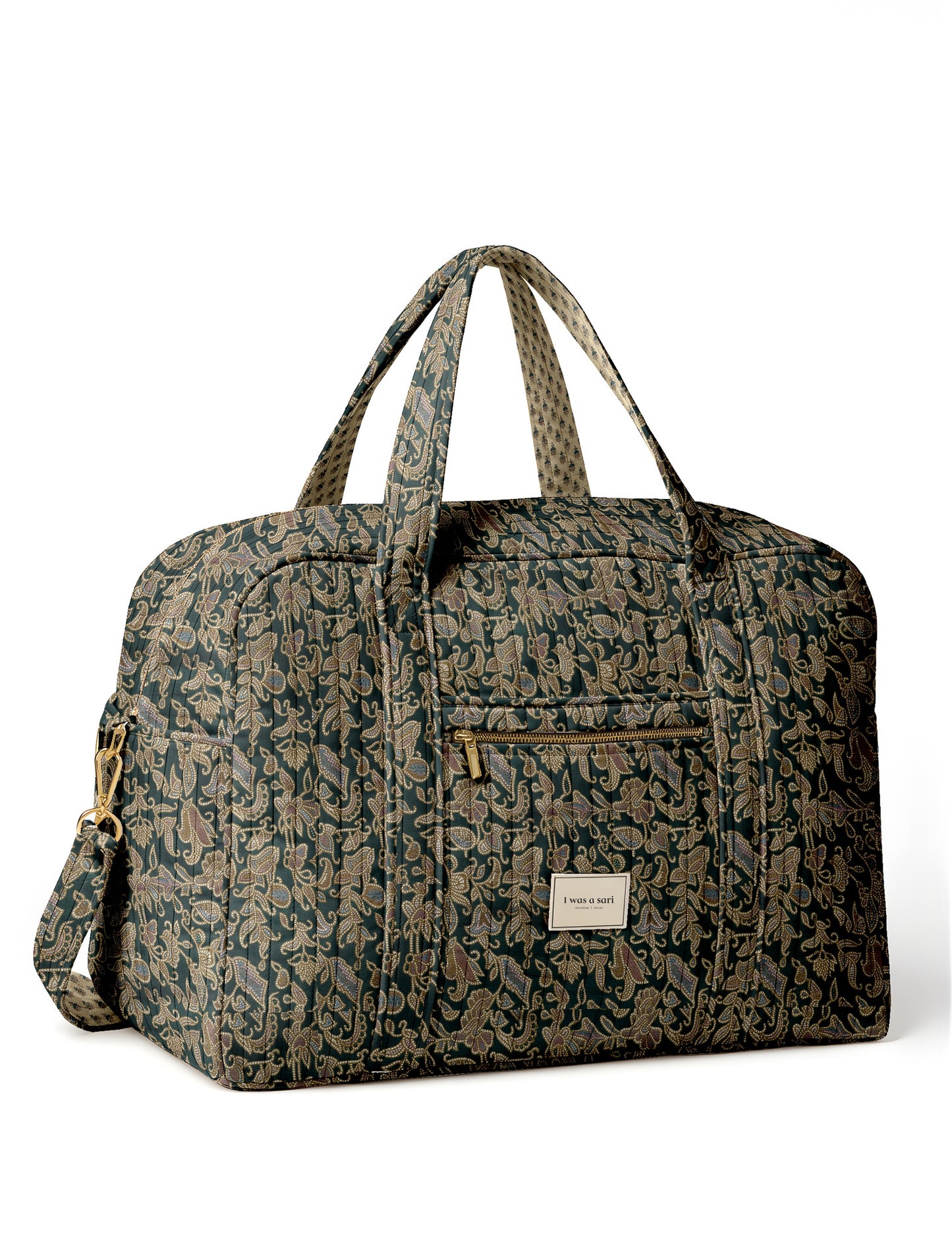 Brown quilted duffle bag with paisley pattern, front zip pocket, dual handles, and label reading "I was a sari"