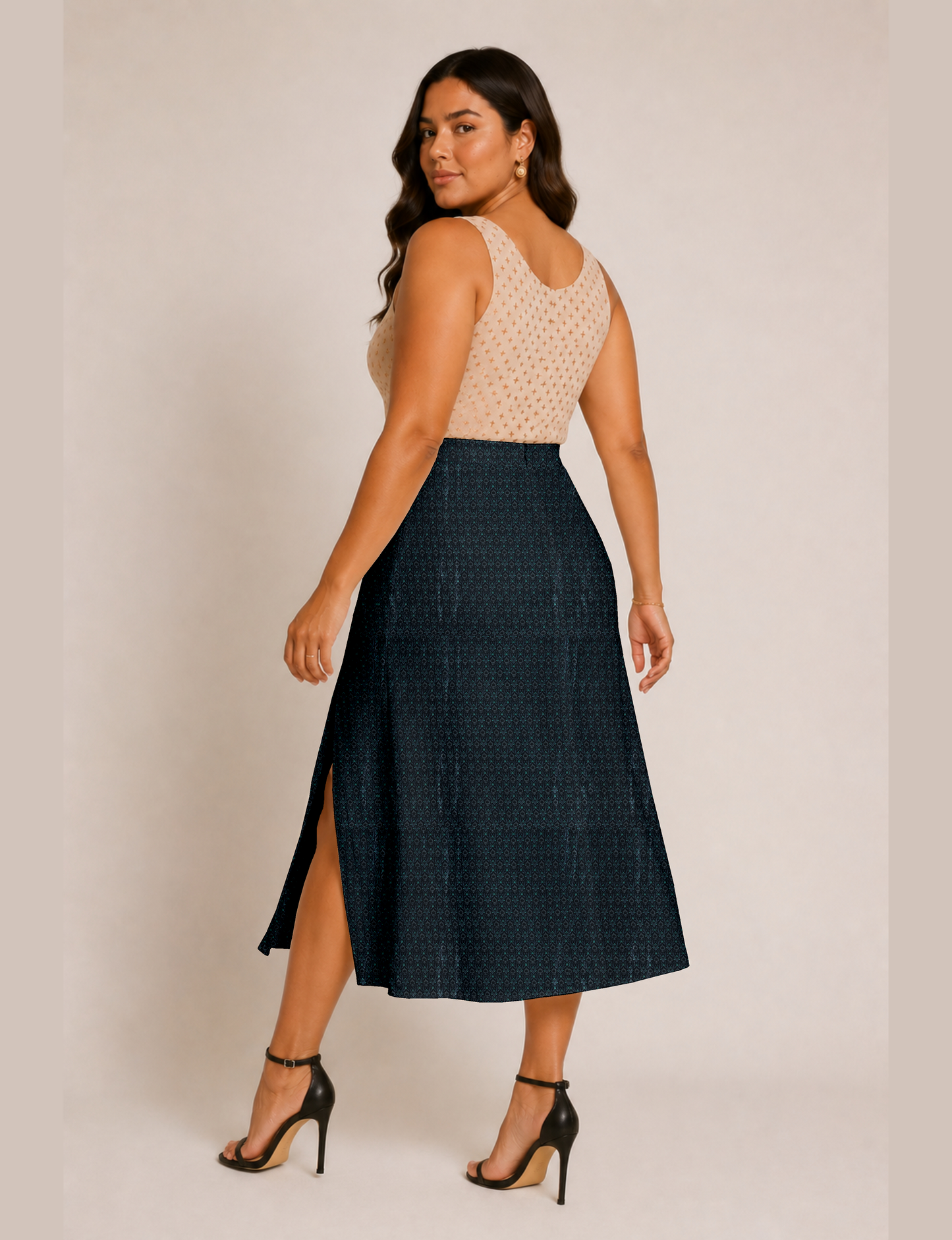 Woman wearing a yellow and black micro patterned A-line skirt with front slit, paired with beige sleeveless top and black