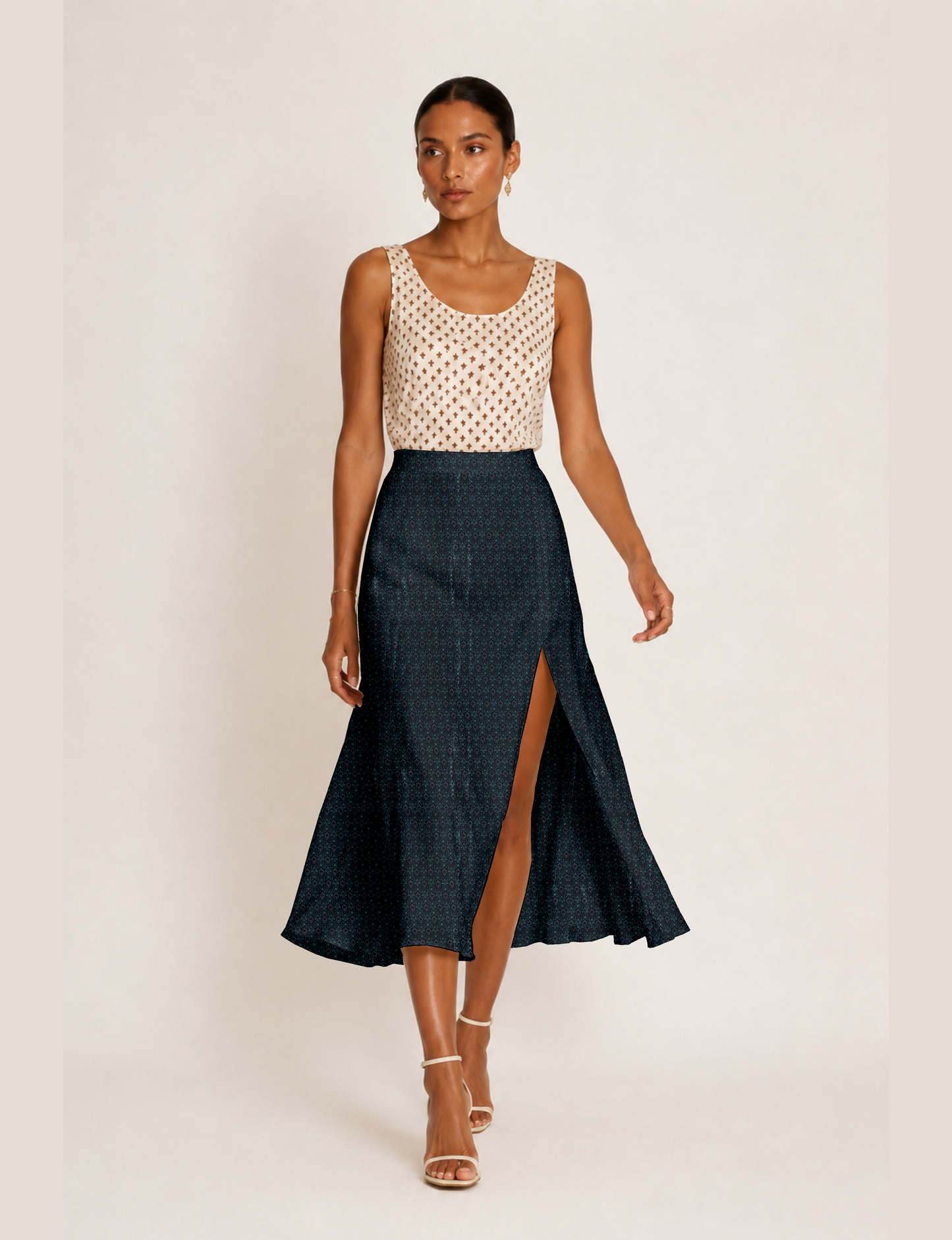 Woman wearing a yellow and black micro patterned A-line skirt with front slit, paired with beige sleeveless top and black