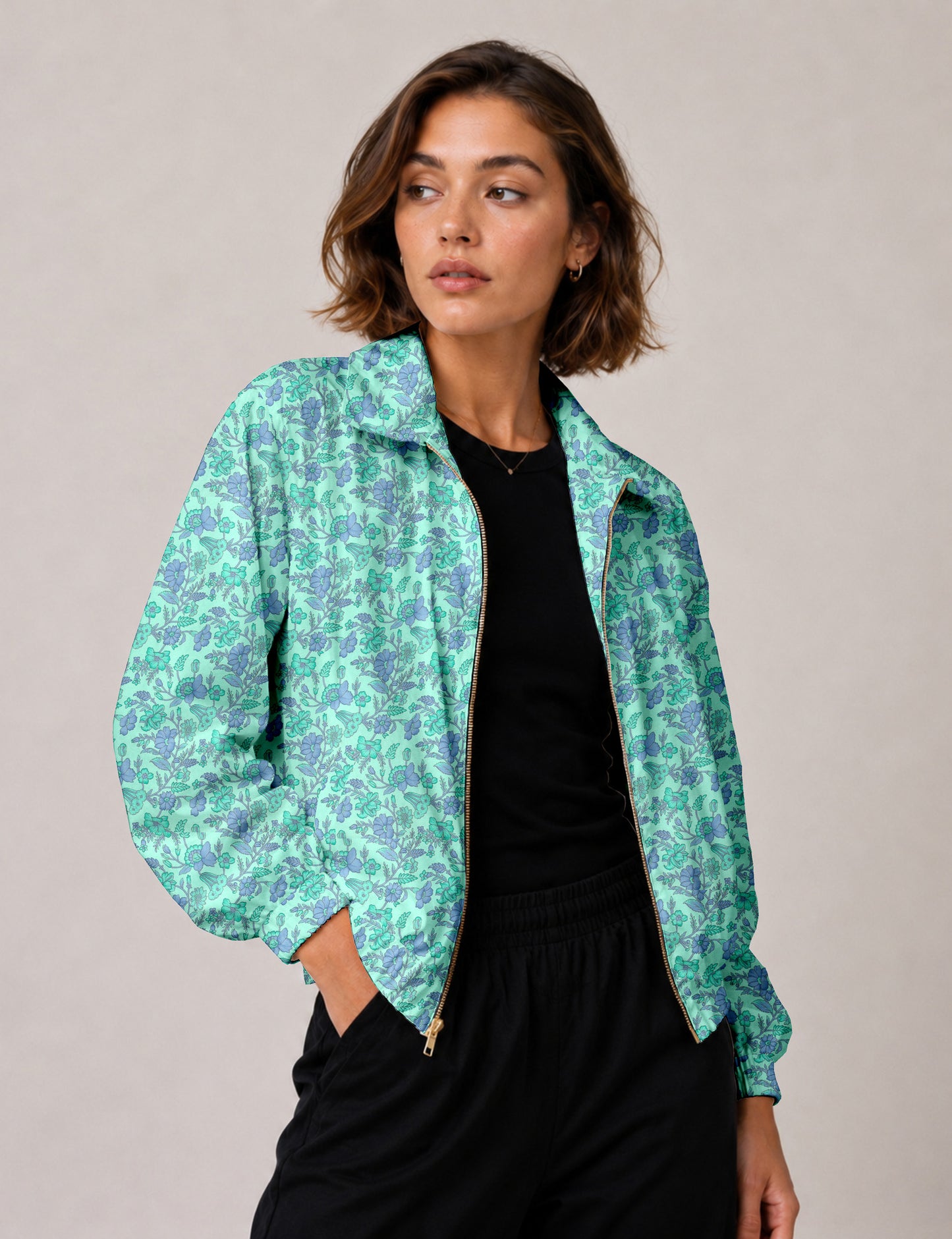 Woman wearing a yellow floral bomber jacket with front zipper, elastic cuffs, and side pockets, shown from front view