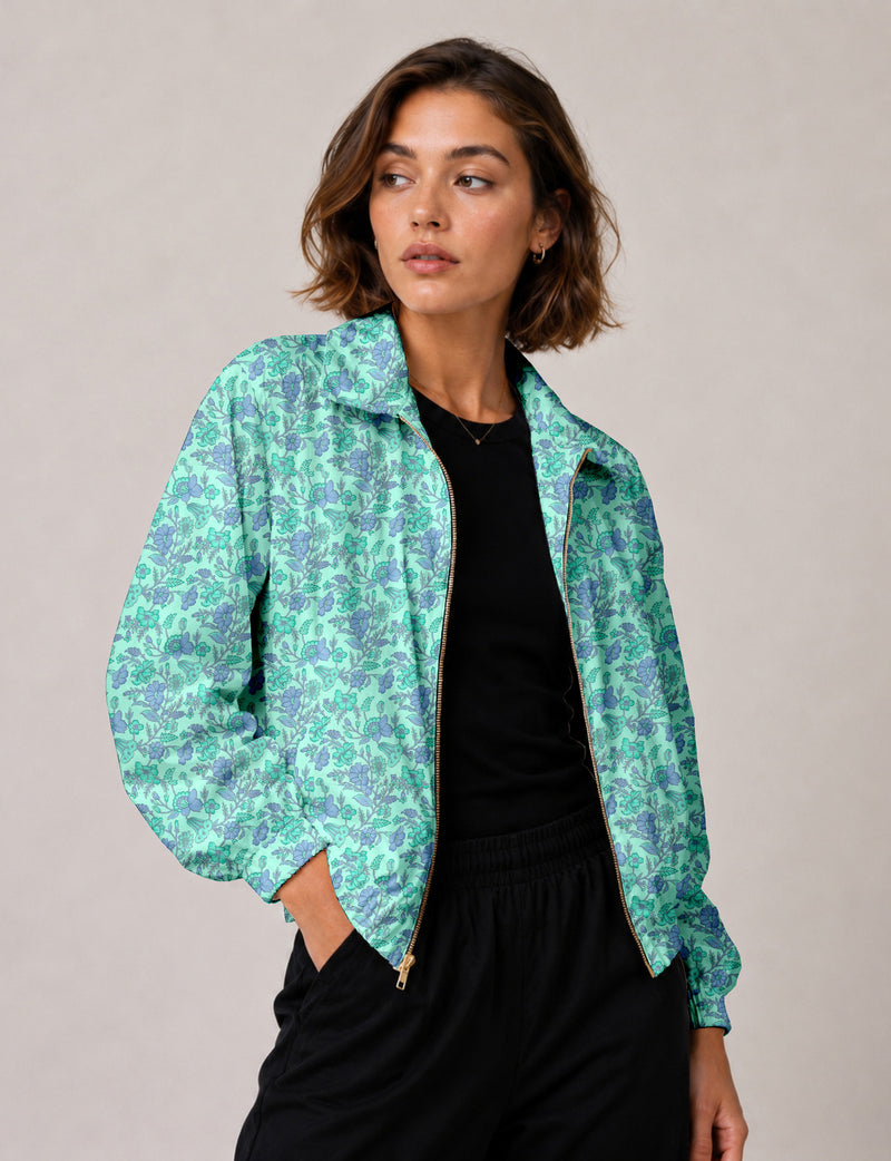 Woman wearing a yellow floral bomber jacket with front zipper, elastic cuffs, and side pockets, shown from front view