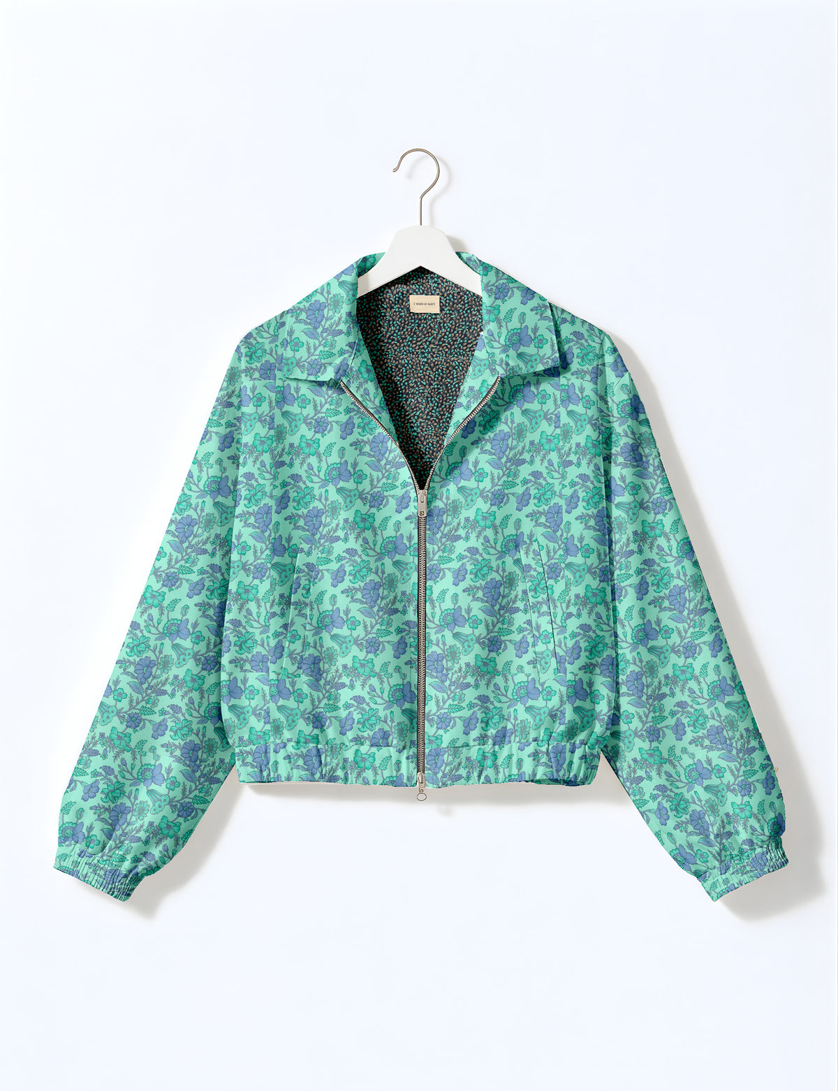 Woman wearing a yellow floral bomber jacket with front zipper, elastic cuffs, and side pockets, shown from front view