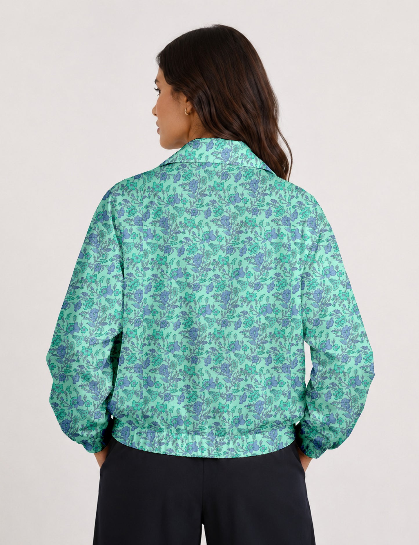 Woman wearing a yellow floral bomber jacket with front zipper, elastic cuffs, and side pockets, shown from front view