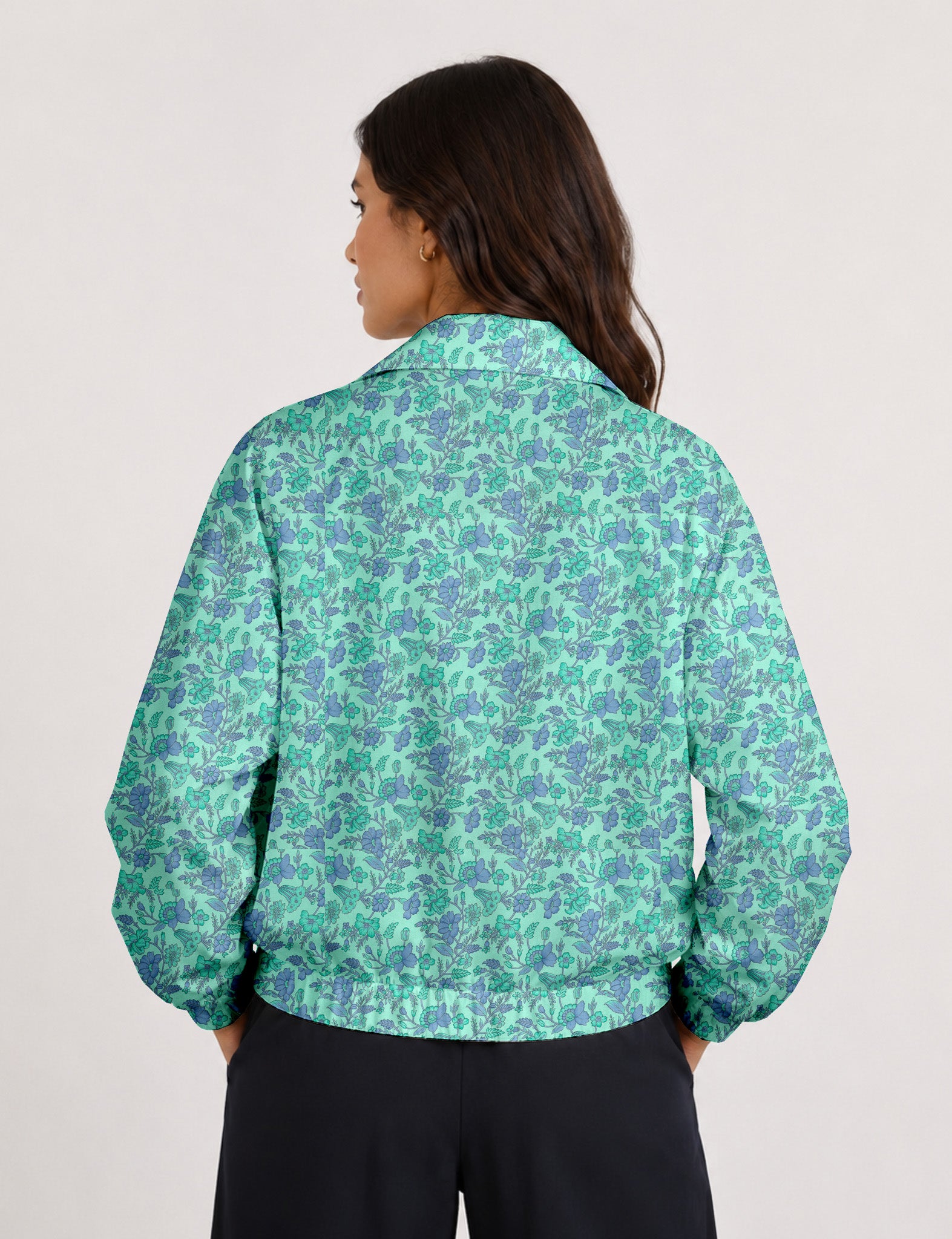 Woman wearing a yellow floral bomber jacket with front zipper, elastic cuffs, and side pockets, shown from front view