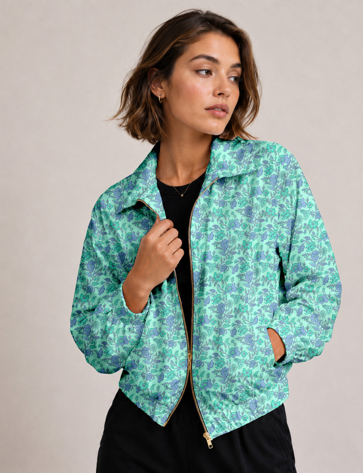 Woman wearing a yellow floral bomber jacket with front zipper, elastic cuffs, and side pockets, shown from front view