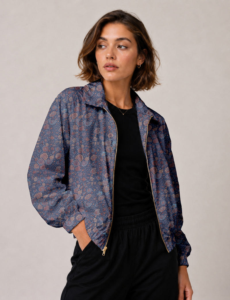Woman wearing a yellow floral bomber jacket with front zipper, elastic cuffs, and side pockets, shown from front view