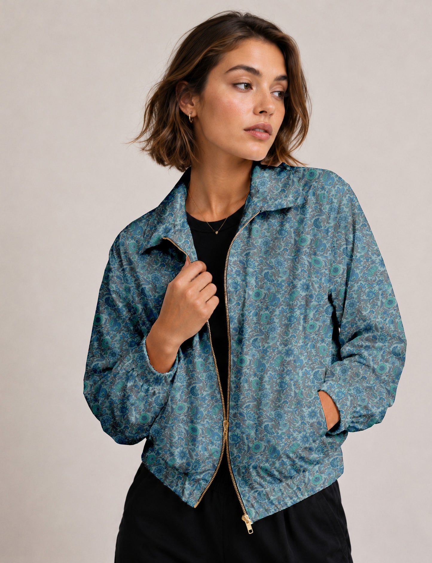 Woman wearing a yellow floral bomber jacket with front zipper, elastic cuffs, and side pockets, shown from front view