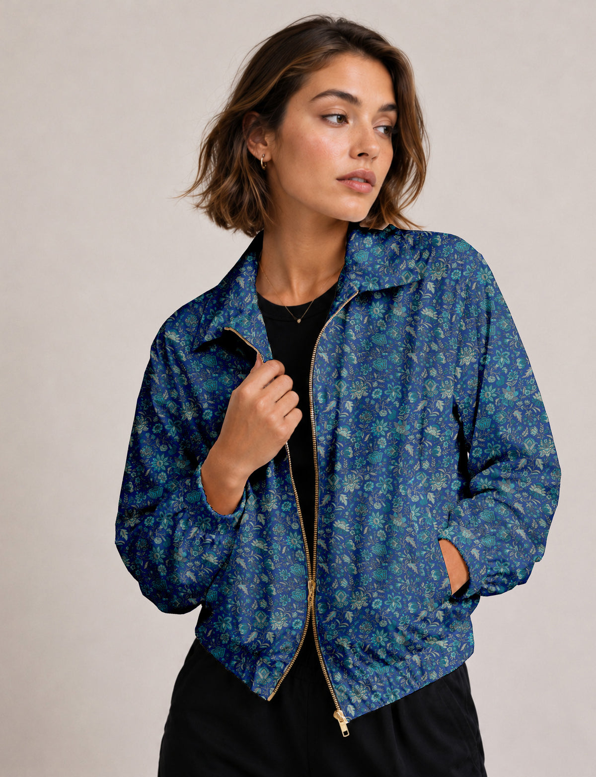 Woman wearing a yellow floral bomber jacket with front zipper, elastic cuffs, and side pockets, shown from front view