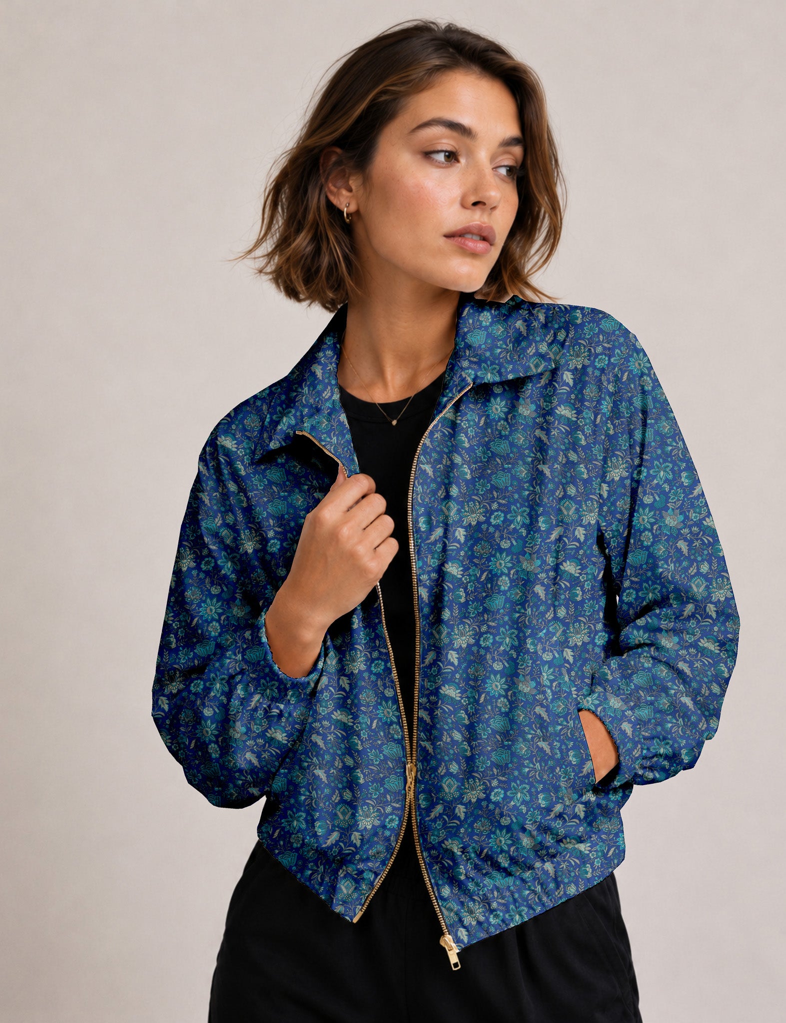 Woman wearing a yellow floral bomber jacket with front zipper, elastic cuffs, and side pockets, shown from front view