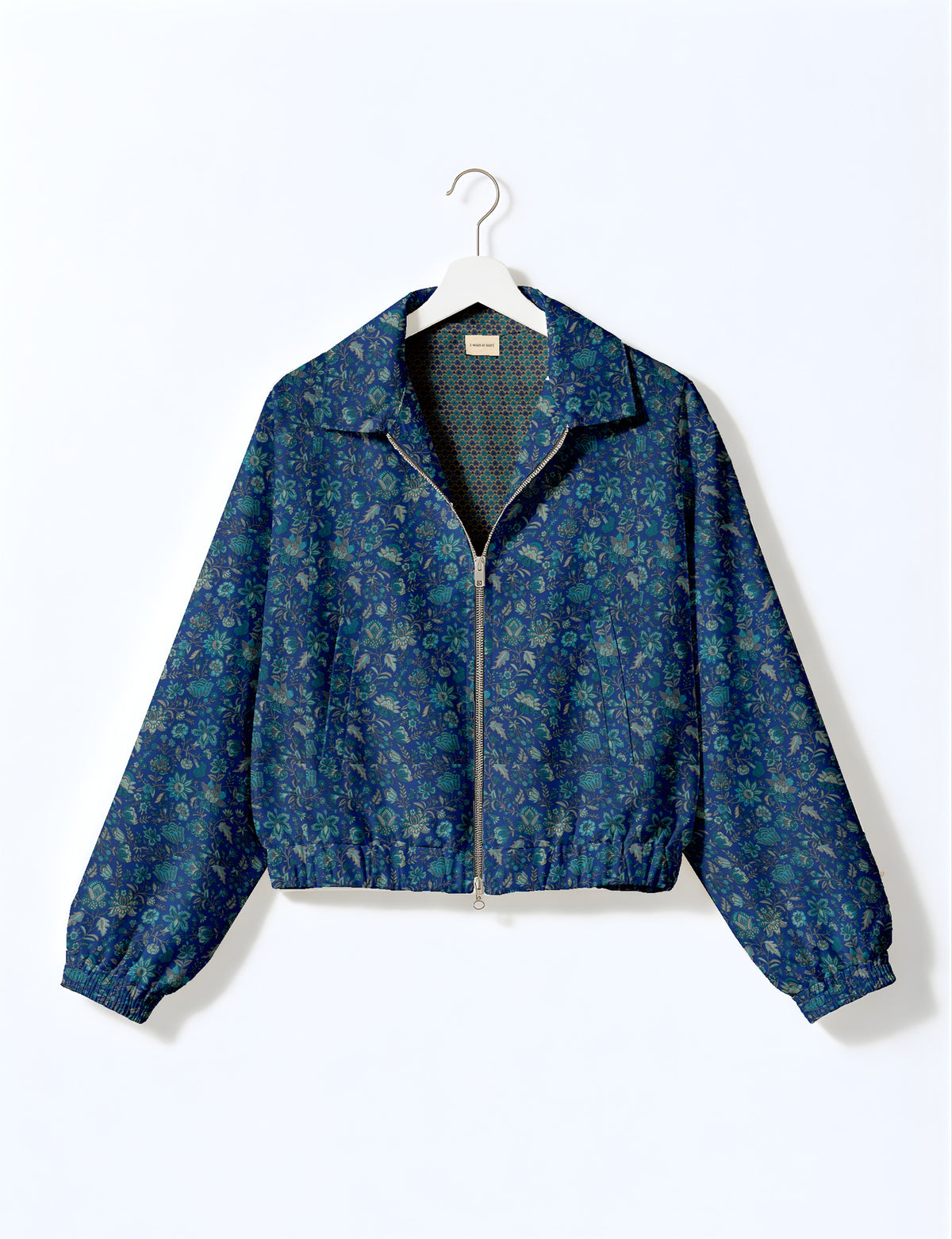 Brown floral bomber jacket with front zipper, elastic cuffs and hem, hanging on white hanger, red floral inner lining visible