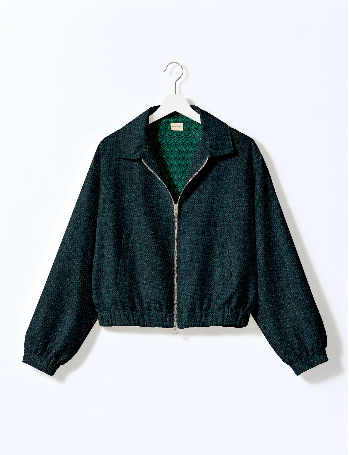 Women's cropped bomber jacket with twin metallic front zippers, welt pockets, elasticated hem and cuffs, and contrast sari print lining.
