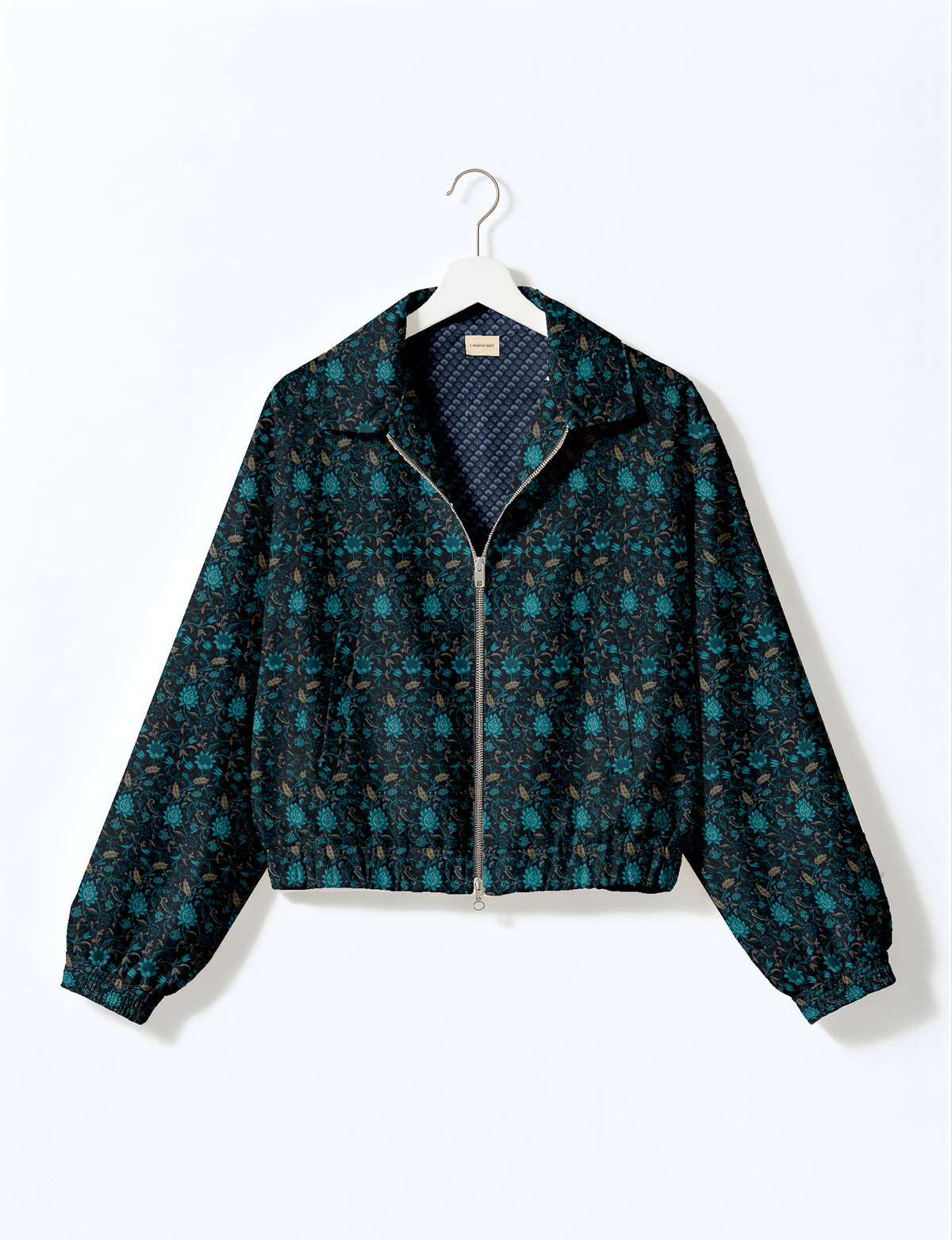 Brown floral bomber jacket with front zipper, elastic cuffs and hem, hanging on white hanger, red floral inner lining visible
