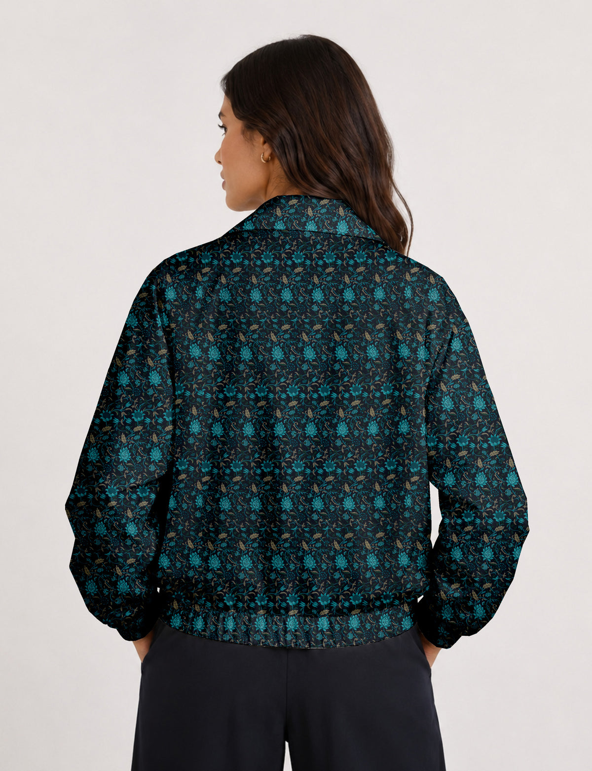 Woman wearing a yellow floral bomber jacket with front zipper, elastic cuffs, and side pockets, shown from front view