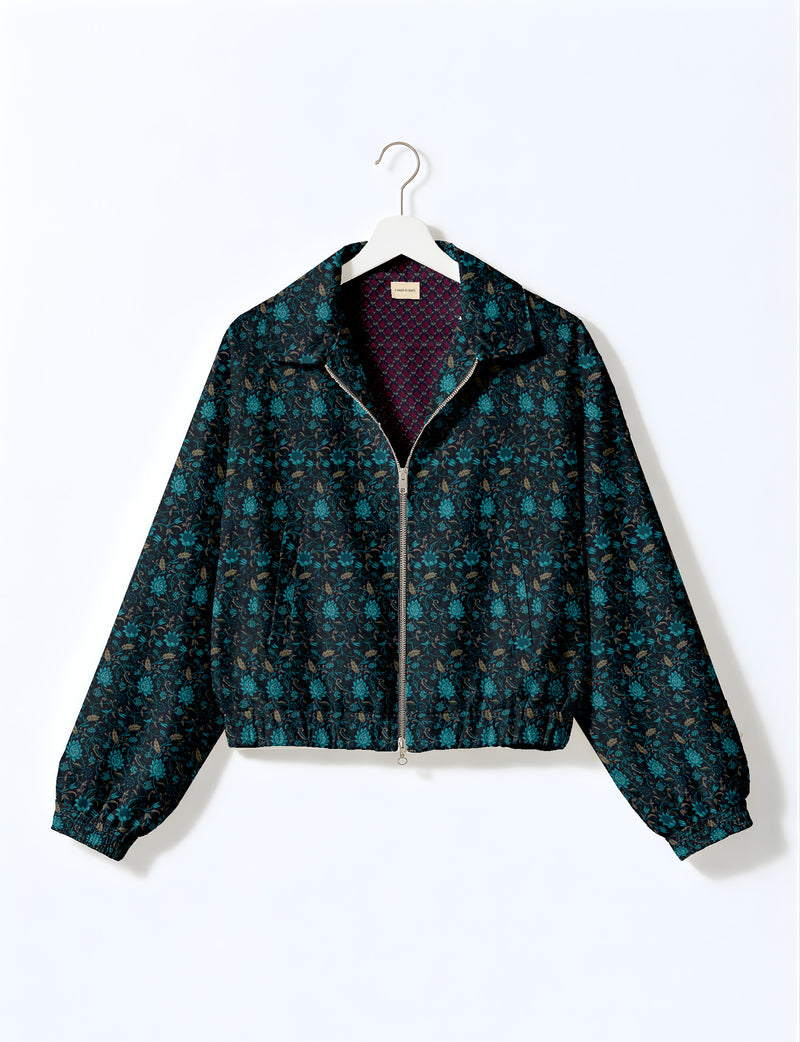 Brown floral bomber jacket with front zipper, elastic cuffs and hem, hanging on white hanger, red floral inner lining visible