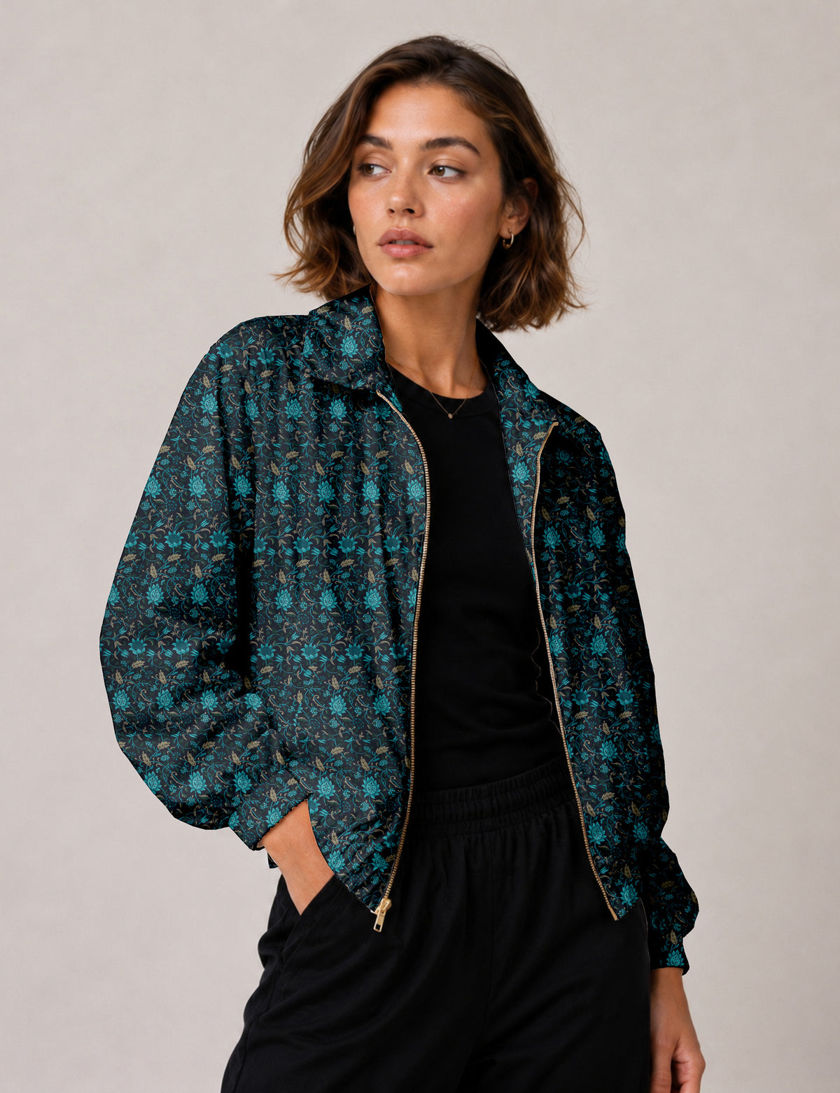 Woman wearing a yellow floral bomber jacket with front zipper, elastic cuffs, and side pockets, shown from front view