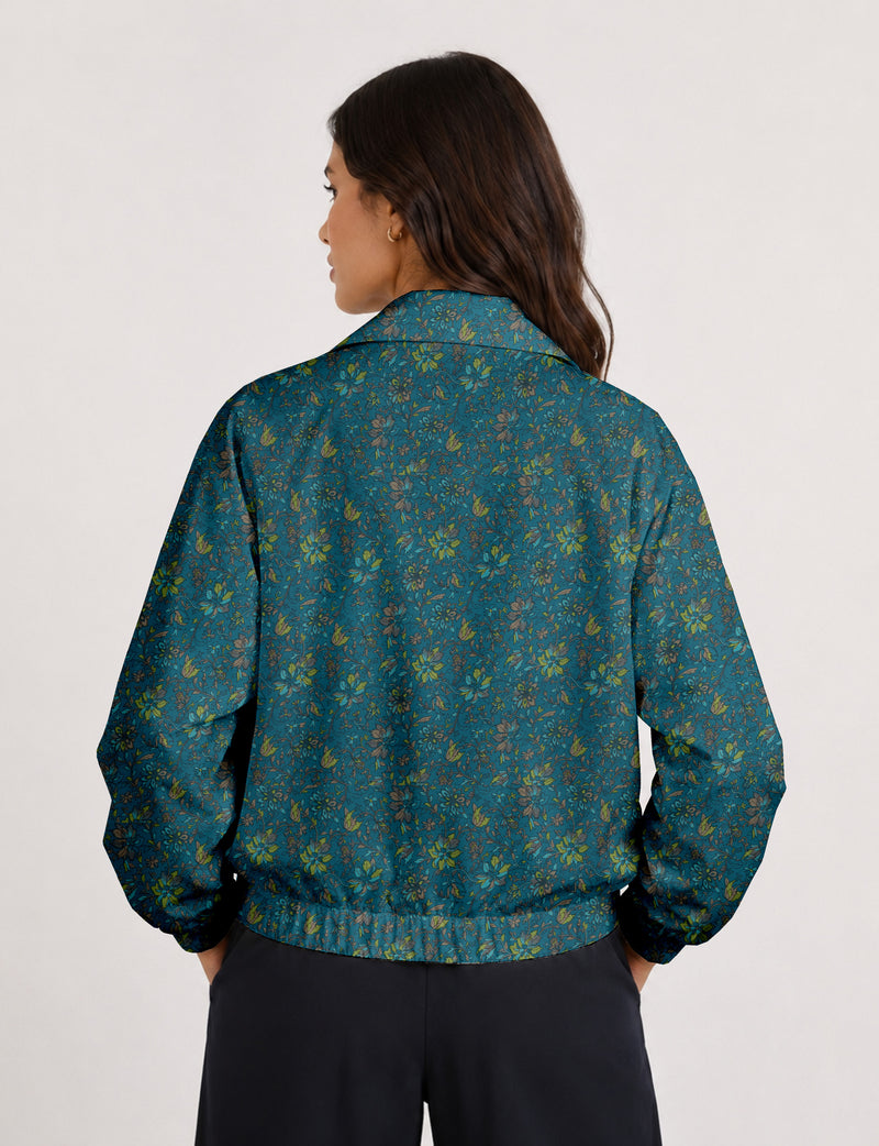 Woman wearing a yellow floral bomber jacket with front zipper, elastic cuffs, and side pockets, shown from front view