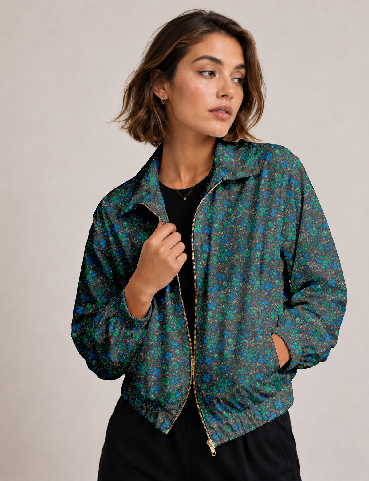Brown floral bomber jacket with front zipper, elastic cuffs and hem, hanging on white hanger, red floral inner lining visible