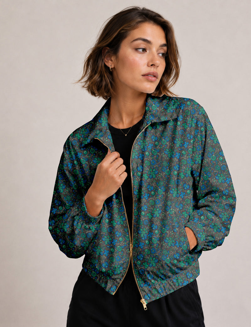 Brown floral bomber jacket with front zipper, elastic cuffs and hem, hanging on white hanger, red floral inner lining visible
