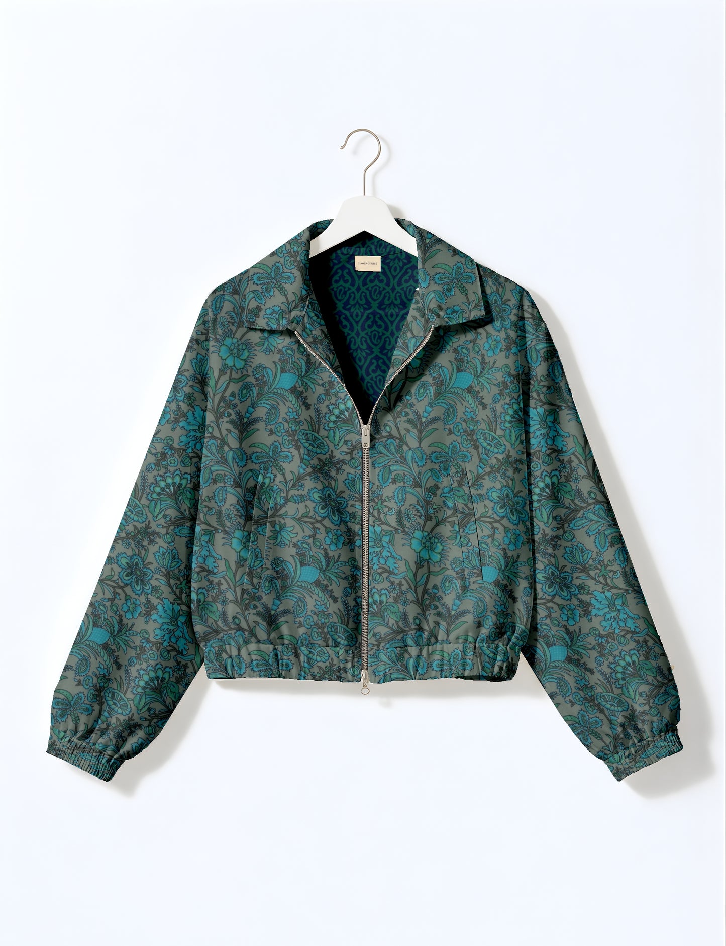 Women's cropped bomber jacket with twin metallic front zippers, welt pockets, elasticated hem and cuffs, and contrast sari print lining.