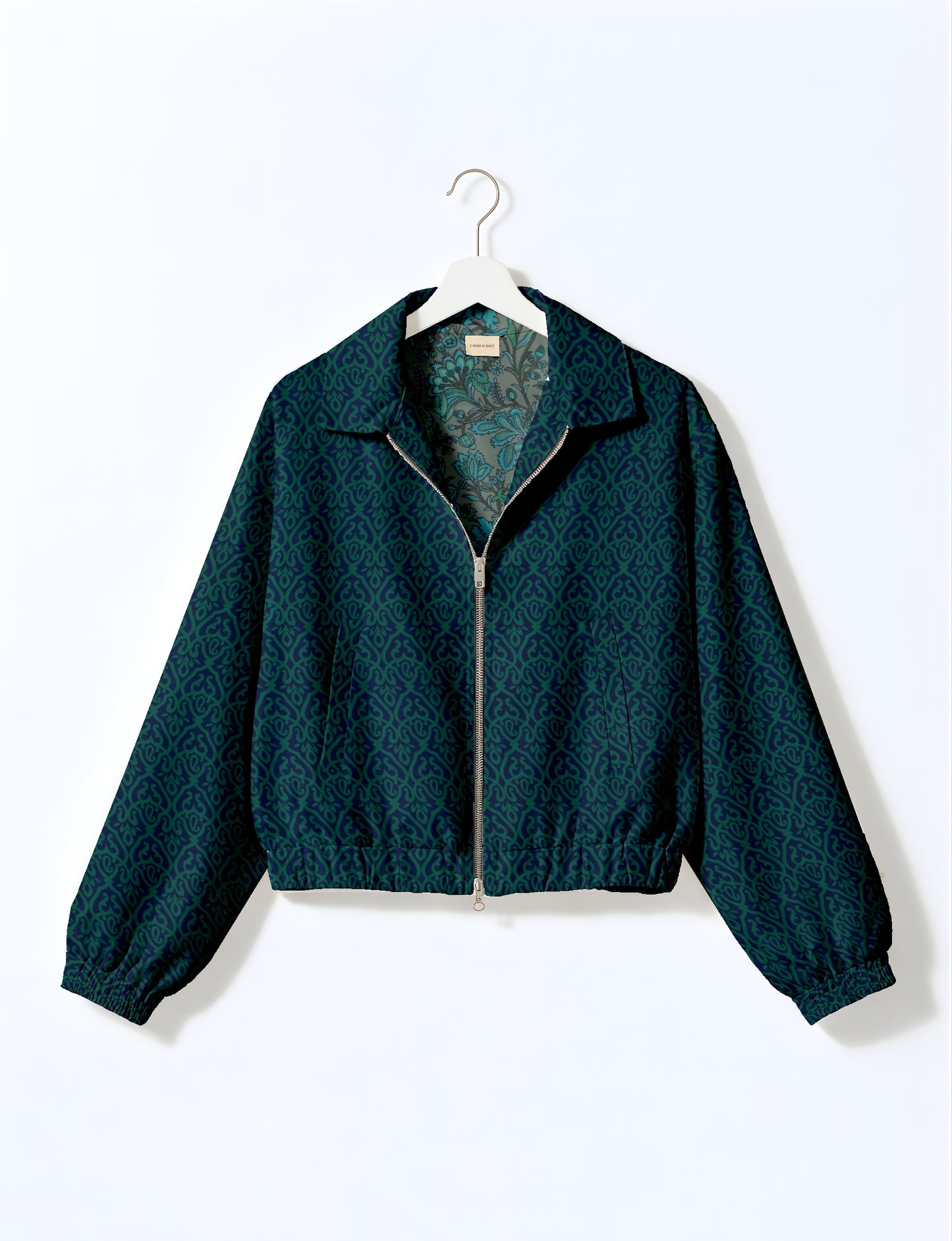 Women's cropped bomber jacket with twin metallic front zippers, welt pockets, elasticated hem and cuffs, and contrast sari print lining.