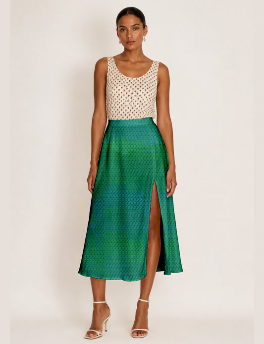Woman wearing a yellow and black micro patterned A-line skirt with front slit, paired with beige sleeveless top and black