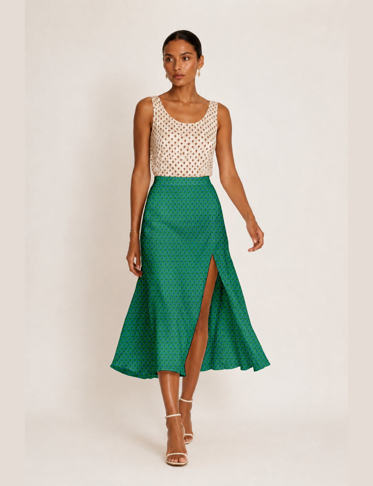 Woman wearing a yellow and black micro patterned A-line skirt with front slit, paired with beige sleeveless top and black