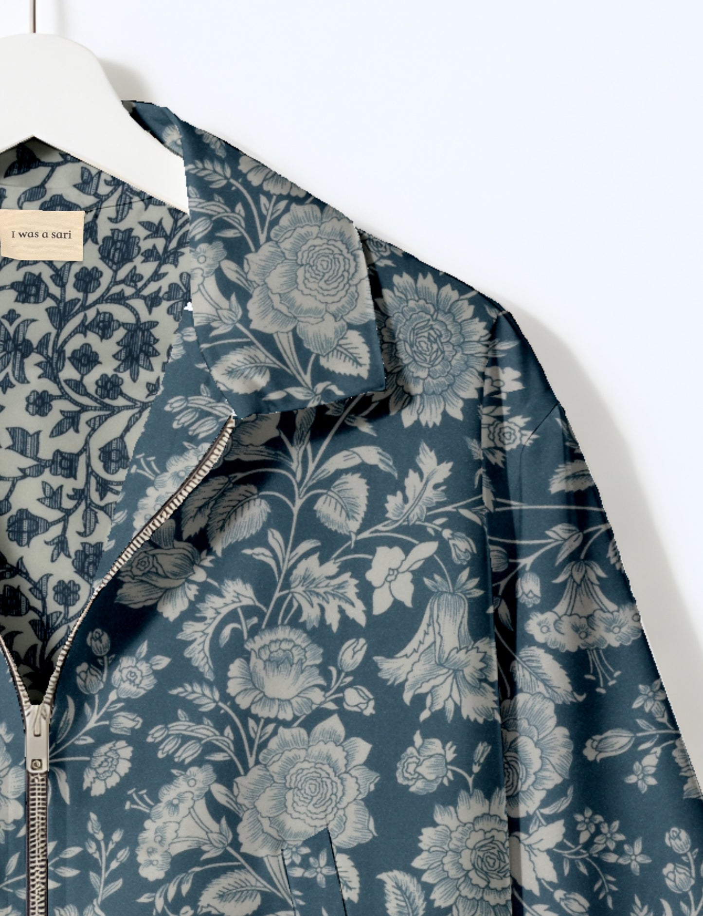 Women's cropped bomber jacket with twin metallic front zippers, welt pockets, elasticated hem and cuffs, and contrast sari print lining.