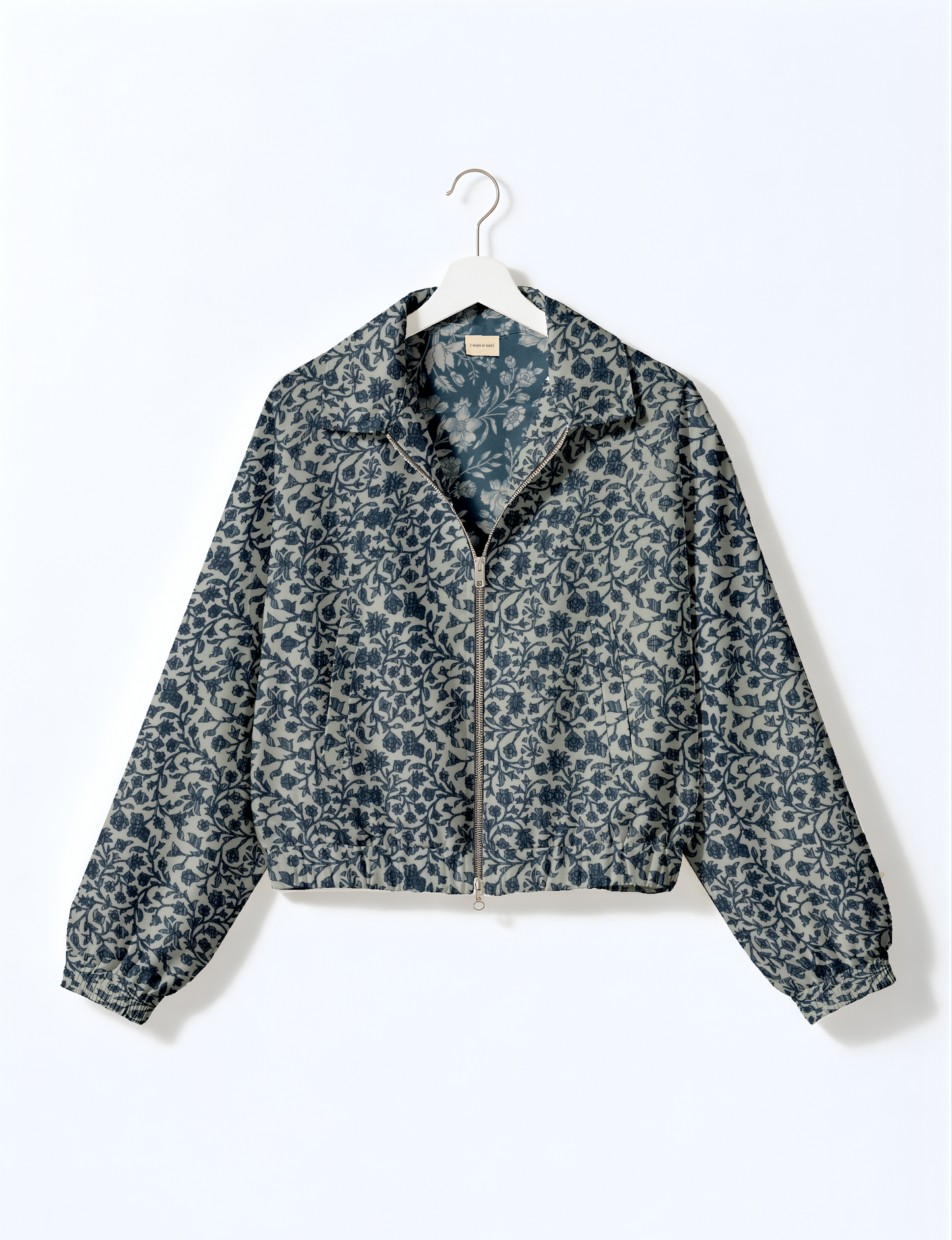 Women's cropped bomber jacket with twin metallic front zippers, welt pockets, elasticated hem and cuffs, and contrast sari print lining.