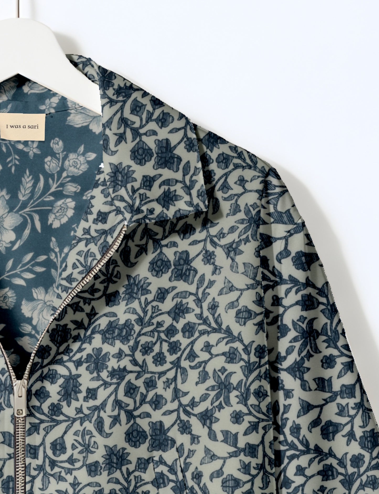 Women's cropped bomber jacket with twin metallic front zippers, welt pockets, elasticated hem and cuffs, and contrast sari print lining.