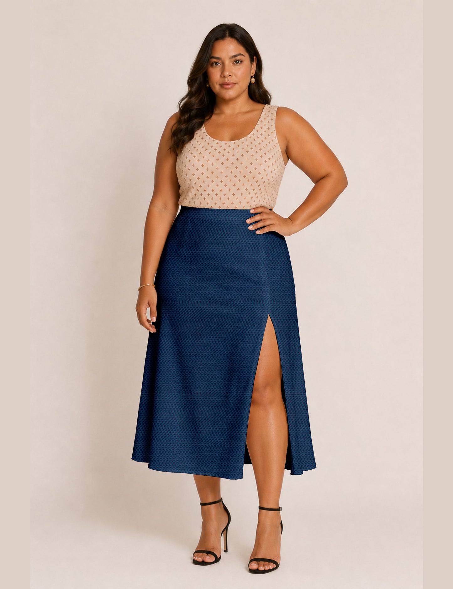 Woman wearing a yellow and black micro patterned A-line skirt with front slit, paired with beige sleeveless top and black