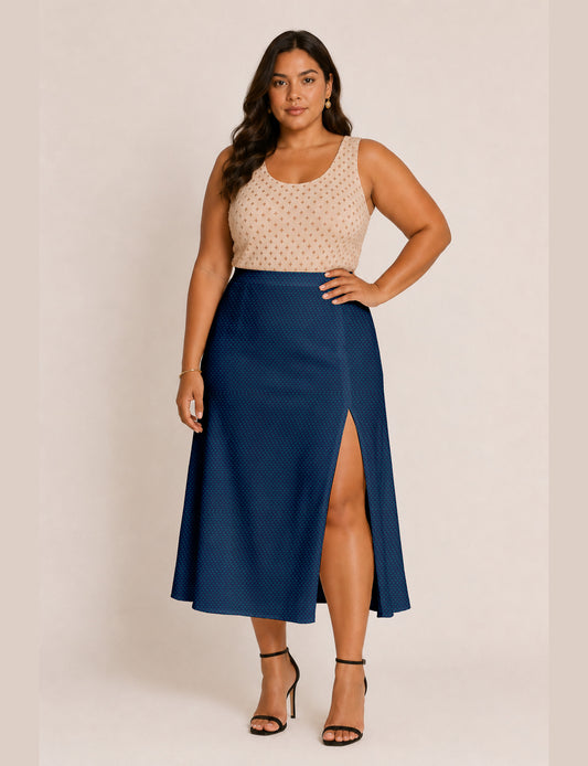 Woman wearing a yellow and black micro patterned A-line skirt with front slit, paired with beige sleeveless top and black