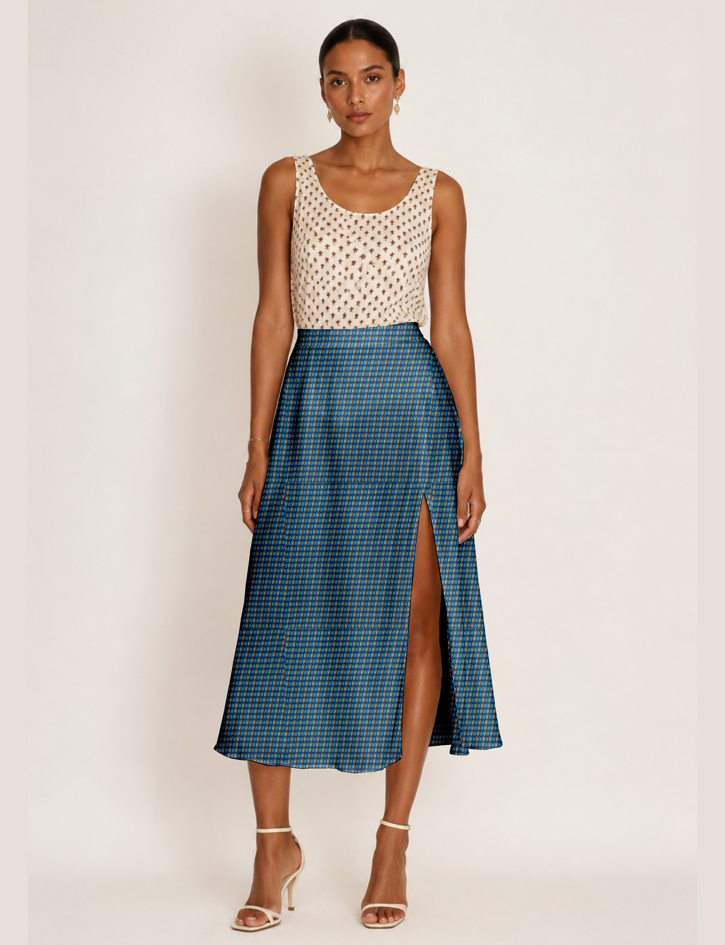 Woman wearing a yellow and black micro patterned A-line skirt with front slit, paired with beige sleeveless top and black