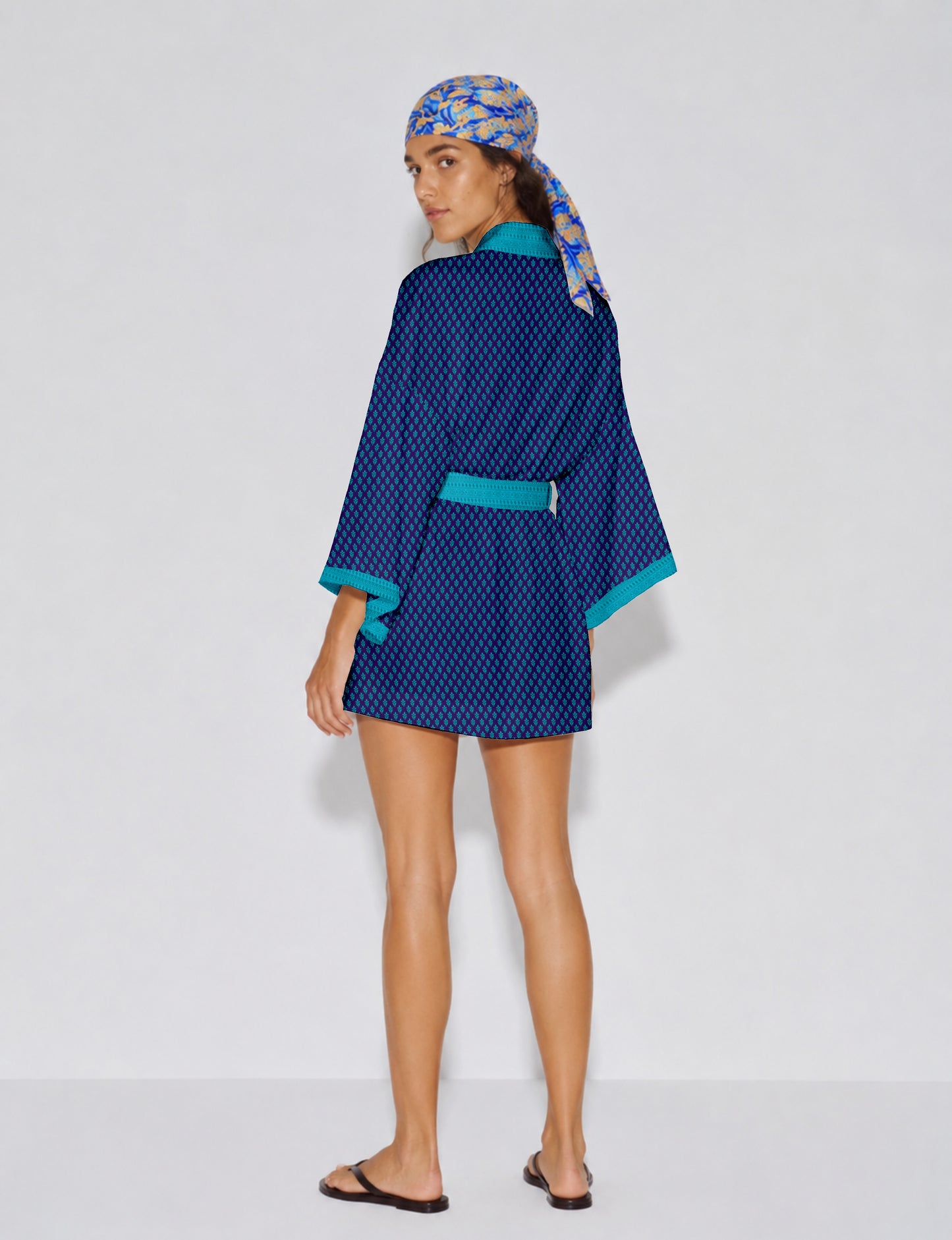 Short kimono robe with wrap front, V-neckline, wide sleeves, waist tie, and concealed skort detail.