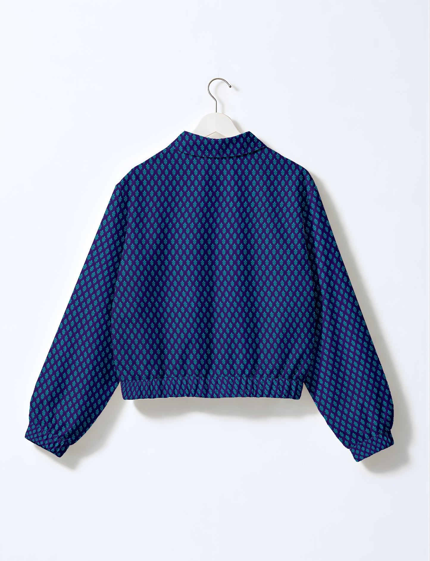 Blue bomber jacket with teal micro diamond pattern, elastic cuffs and waistband, shown from back on white hanger