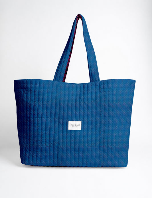 Large quilted beach bag with spacious rectangular design, reinforced shoulder straps, and open-top construction for everyday use and travel.