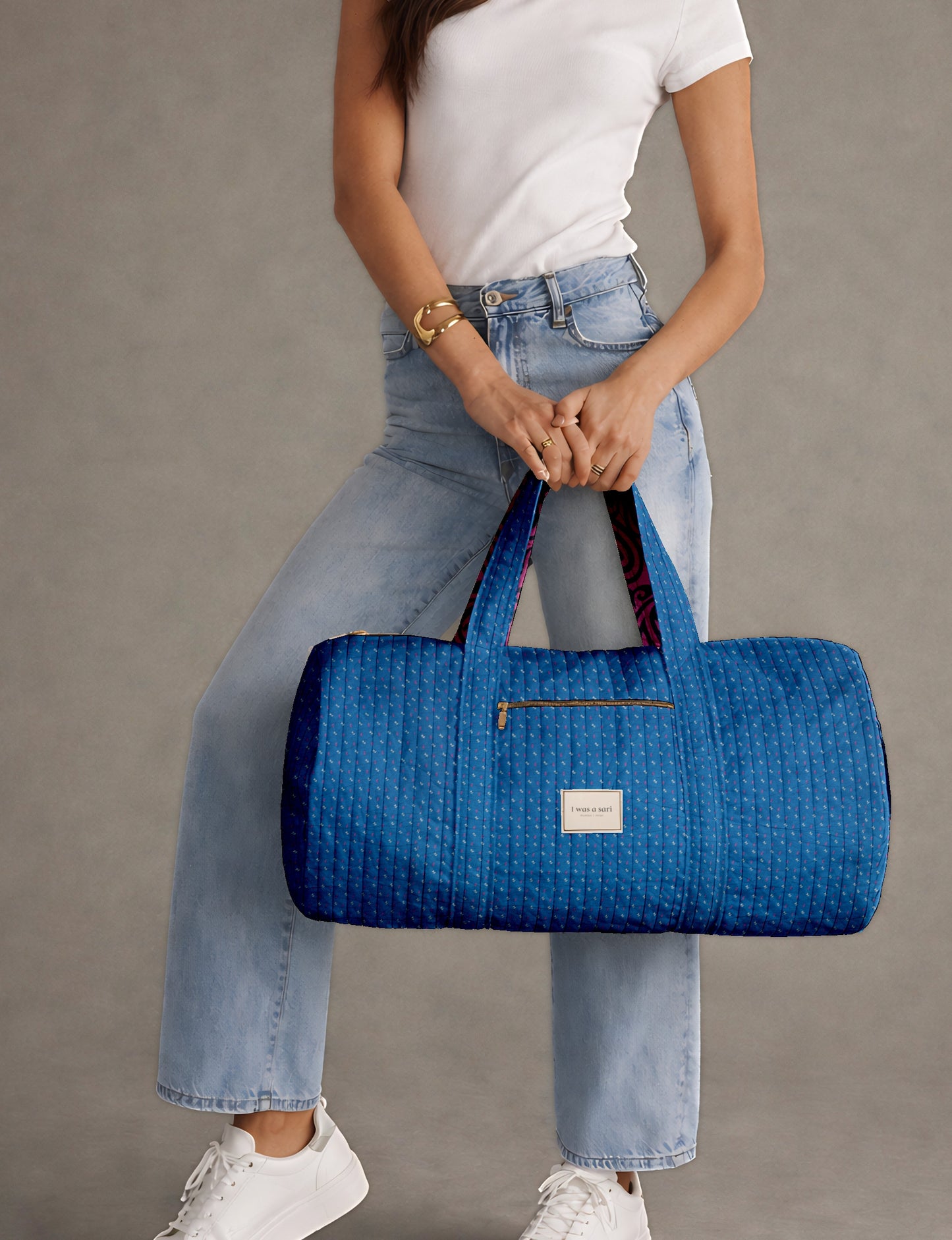 Beige quilted bowling bag with micro floral print exterior and blue geometric patterned interior, open zipper view