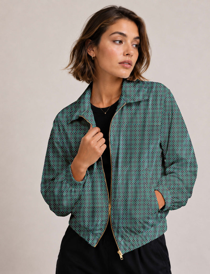 Woman wearing a blue bomber jacket with a micro geometric pattern, gold zipper, and side pockets, shown from front angle