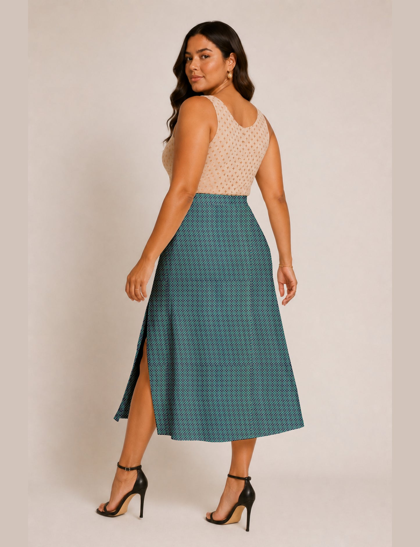 Woman wearing a yellow and black micro patterned A-line skirt with front slit, paired with beige sleeveless top and black
