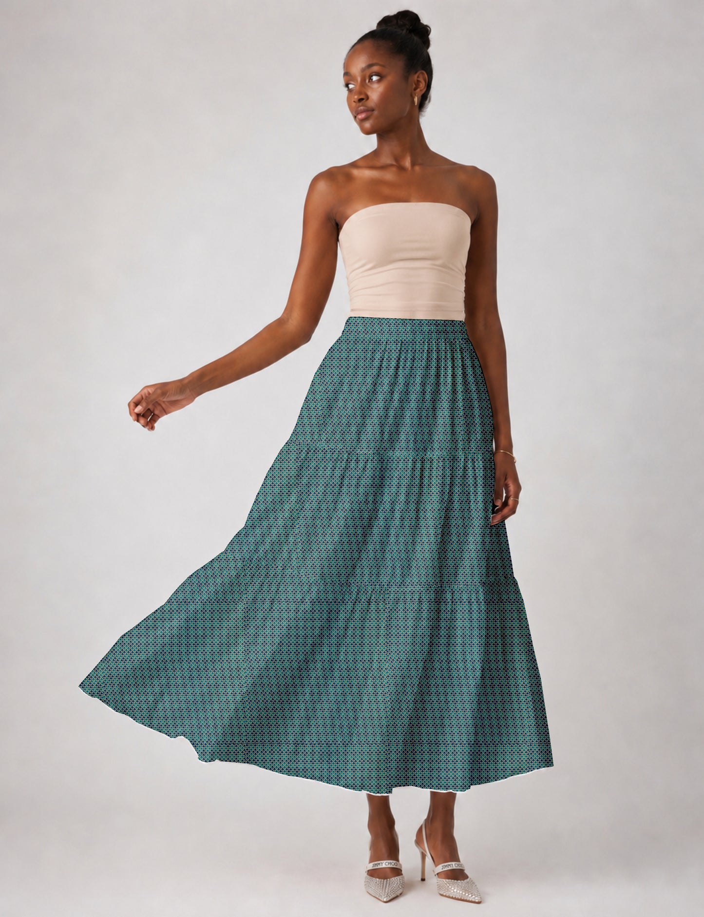 Woman wearing a yellow midi tiered skirt with a small geometric pattern, shown from the back, paired with beige top and