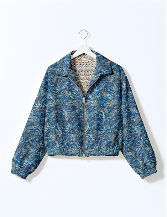 Women's cropped bomber jacket with twin metallic front zippers, welt pockets, elasticated hem and cuffs, and contrast sari print lining.