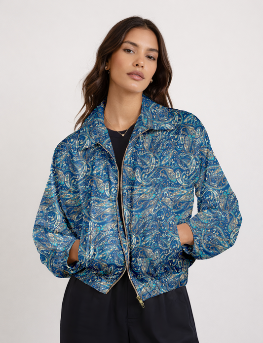 Women's cropped bomber jacket with twin metallic front zippers, welt pockets, elasticated hem and cuffs, and contrast sari print lining.