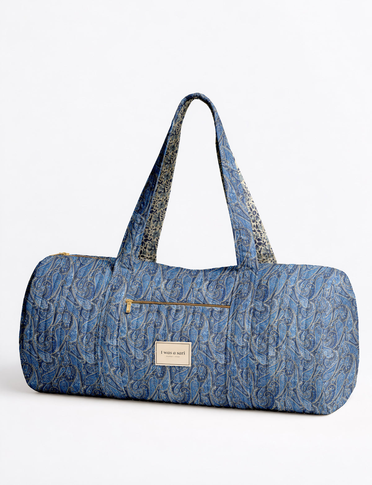 Brown paisley quilted bowling bag with dual handles, front zipper pocket, and "I was a sari" label on front side